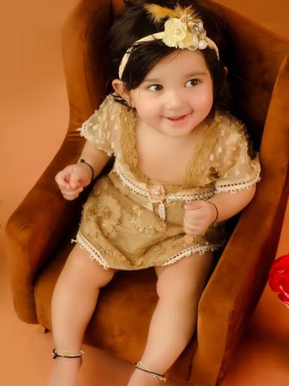A close-up of the little queen in her golden-themed photoshoot. The warm tones and luxurious props create a truly regal portrait.