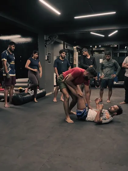 A demonstration of a grappling technique in front of a class, showing the proper way to control an opponent.