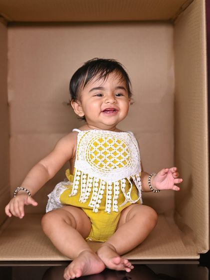 Sometimes the simplest ideas are the best. A plain cardboard box can become the perfect prop to capture a baby's happy smile and playful personality.