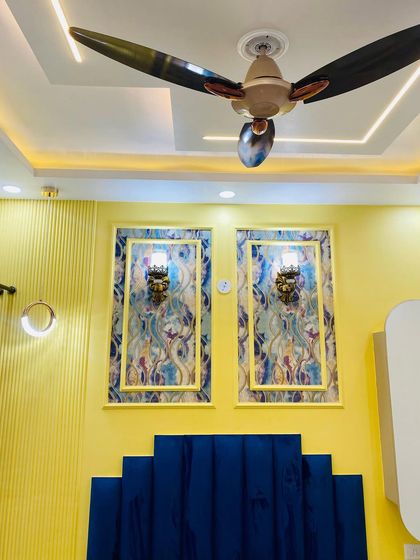 This shot highlights the decorative wall panels and classic wall lights above the royal blue headboard.