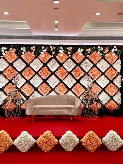 A modern sofa provides a contemporary touch to the elaborate floral cushion backdrop, showing our ability to mix different styles seamlessly.