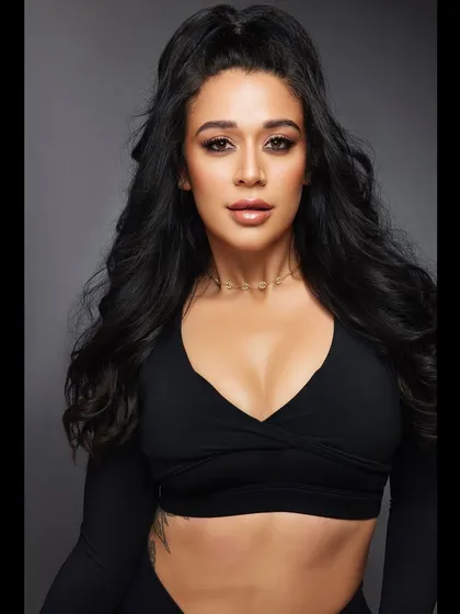 A direct shot showcasing the height and texture of the half-ponytail. The dark, glossy hair looks incredibly healthy and full, perfect for a fitness or beauty campaign.
