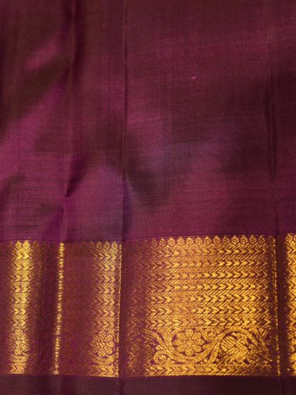 A close-up of the rich violet border with its handwoven gold zari, a classic design that speaks of timeless elegance.
