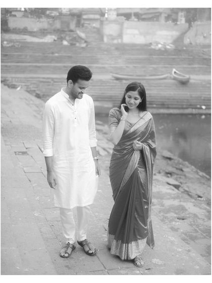 A timeless black and white photograph of the couple walking by the water, emphasizing emotion and classic composition.