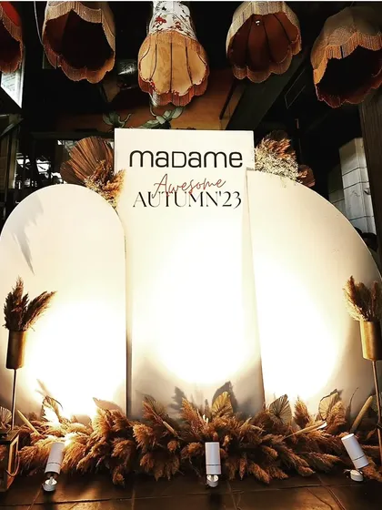 A custom-branded photo backdrop for the Madame Fashions event. The simple, elegant arches and warm lighting provided the perfect setting for guests and influencers to capture content with the new collection.