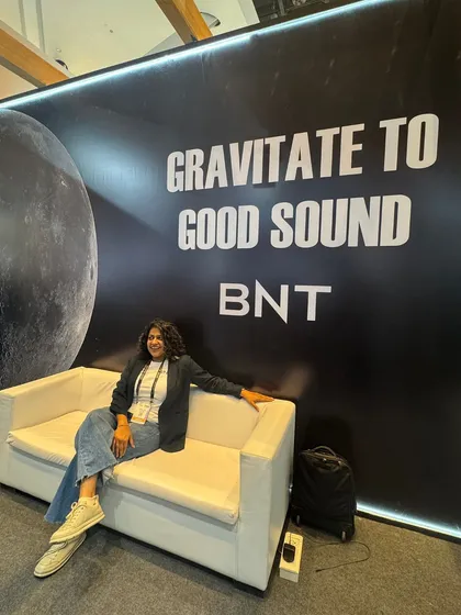 Jenny taking a well-deserved break at our "Gravitate to Good Sound" photo wall. We believe good sound has a powerful pull, and we love creating spaces that celebrate it.
