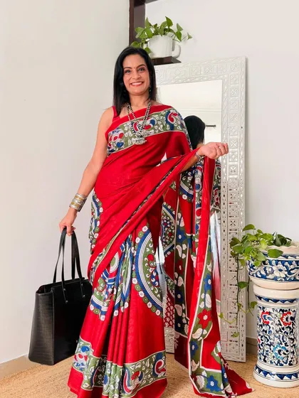 This red cotton Mulmul saree with a vibrant, multi-colored print is so full of life. It's a cheerful saree that is sure to brighten your day.