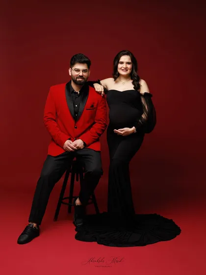 A portrait of partnership and anticipation. I love capturing the strength and connection between couples as they await their new arrival, using bold colors like red and black to reflect their passion.