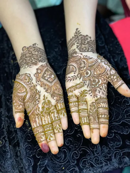 This design showcases a beautiful mix of styles, with one hand featuring a geometric diamond pattern and the other a more organic, flowing design.