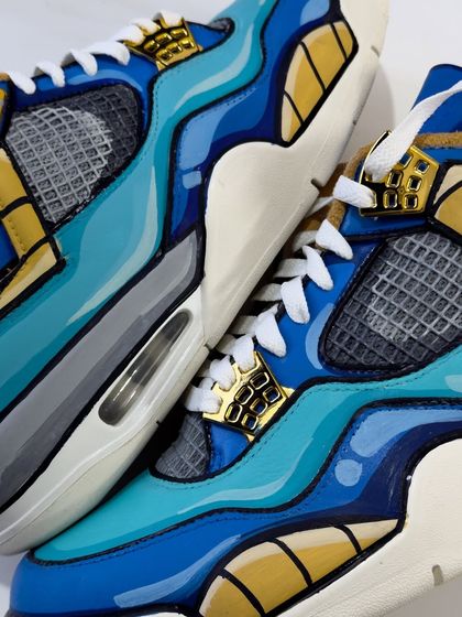 A close up of the Vegeta custom Jordans. The metallic gold paint really shines and contrasts with the cool blue tones.