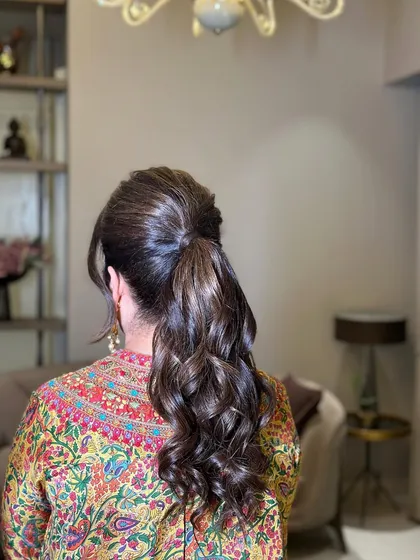 A messy ponytail with a slight puff at the front, a popular choice for a chic and modern look.