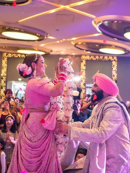 The playful and joyous Varmala exchange during a Sikh wedding, a moment filled with laughter and celebration.