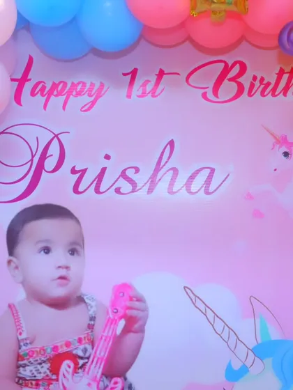 A detailed shot of the personalized 'Happy 1st Birthday' backdrop, featuring the birthday girl's name and photo.