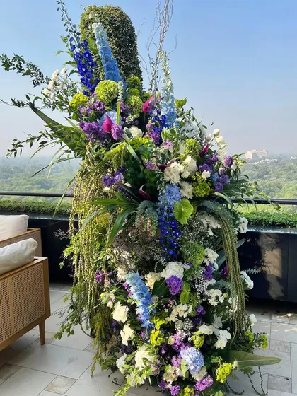 This outdoor installation is what I call beautiful chaos. I combined lush greens, vibrant purples, and dreamy blues to create a floral odyssey that feels wild and untamed, yet perfectly composed. It’s about going bold and letting the flowers tell their own story.