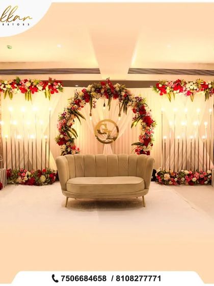 A modern reception stage with a floral arch and the couple's monogram. The clean lines and beautiful flower arrangements make for a chic and personalized setup.
