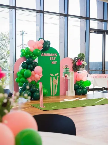 For a future cricket star, I designed this "Amirah's 1st Hit" theme. The setup includes a green "pitch" floor, cricket stumps, and a pink and green color scheme.