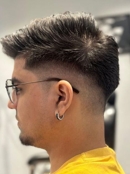 A sharp and clean fade haircut for a male client. The seamless blend from the skin to the longer hair on top is expertly done.