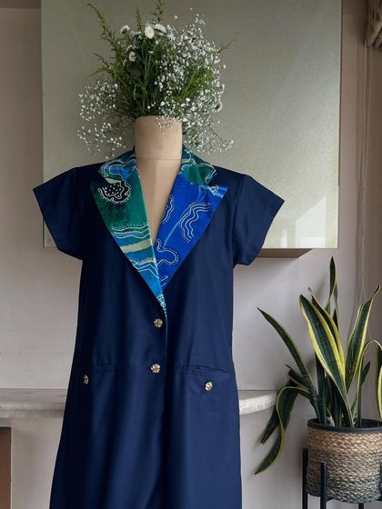 The Komorebi blazer dress on a mannequin, styled with a floral arrangement to emphasize its connection to nature and art. It’s where elegance becomes its own kind of power.