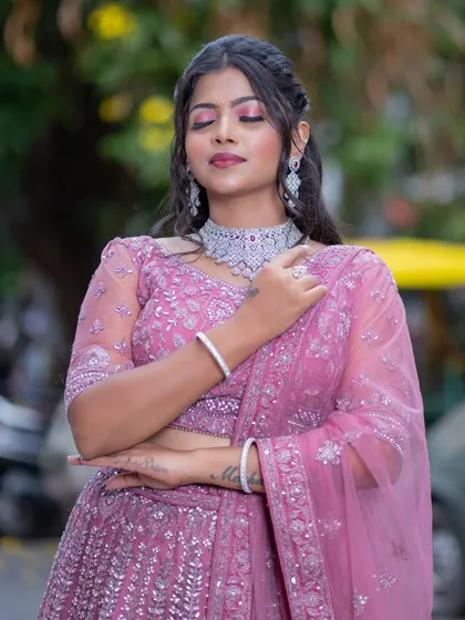 A full-length view of the pink lehenga look. This shows how the soft makeup and hairstyle work with the entire outfit for a complete, elegant appearance.