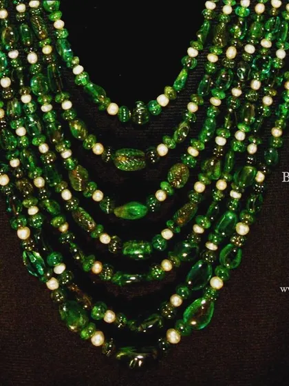 This magnificent seven-line necklace is a prime example of the heritage jewels we source for discerning collectors. It features Colombian and Brazilian emerald beads, Basra pearls, and a stunning clasp of gold minakari studded with diamond polkis and Burmese rubies, showcasing exquisite kundan work.