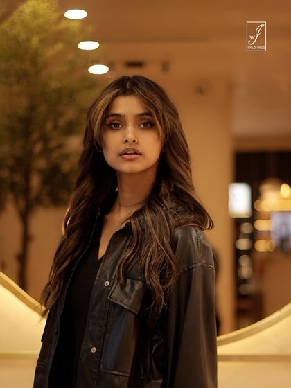 A beautiful portrait with soft lighting that highlights the model's features and hair, set against a warm, inviting indoor location.