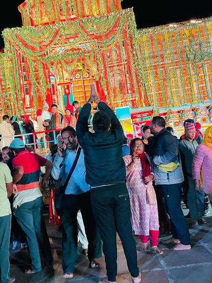 Praying before the beautifully illuminated Badrinath Temple at night. These moments of devotion provide immense peace and strength.