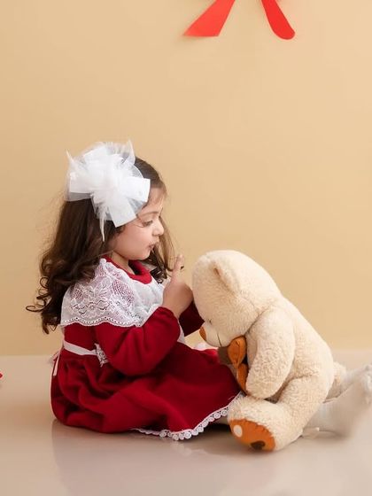 A quiet moment between a girl and her teddy bear, sharing secrets in our Valentine's Day setup.
