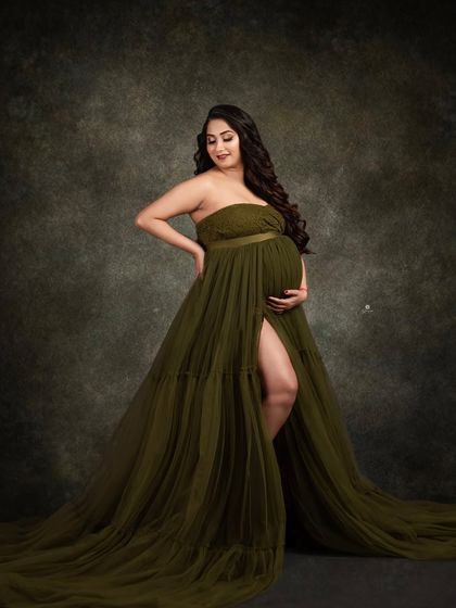 A beautiful solo portrait in a strapless olive green tulle gown. The dark, moody background provides a lovely contrast, making the client and her dress the focal point.