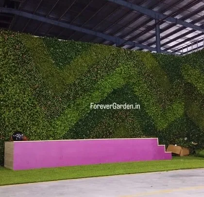 A wide shot of the event stage with the custom artificial green wall, demonstrating how we can create branded environments for corporate functions.