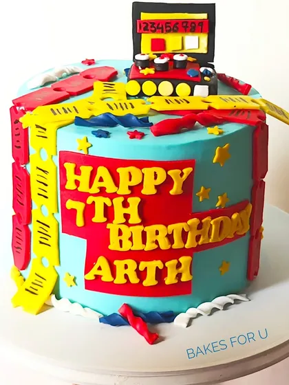 A bright and colorful Timezone arcade-themed cake for a 7th birthday. The design is packed with fun details like game tickets and an arcade machine topper, perfect for a little gamer.