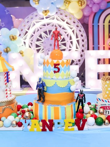 An incredible display of themed cakes, including a carousel cake and a multi-tiered carnival cake, creating a stunning dessert table.