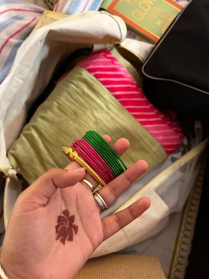 A detail shot of the bride's mehendi and the colorful bangles chosen to complement her Laheriya Haldi outfit.