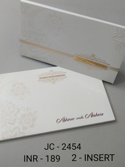 This minimalist white boxed invitation features a simple gold band and subtle embossed floral details. It's a perfect example of understated elegance for a modern wedding.