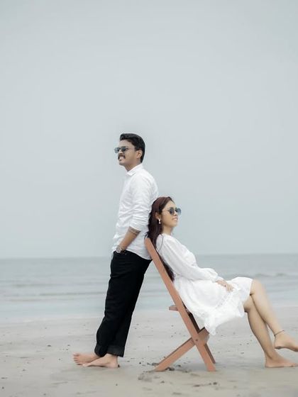 A classic back-to-back pose on the beach, conveying a sense of partnership and cool confidence.
