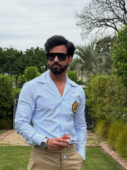A closer look at the blue striped shirt, highlighting the crisp fabric and the elegant, embroidered crest that adds a touch of exclusivity.