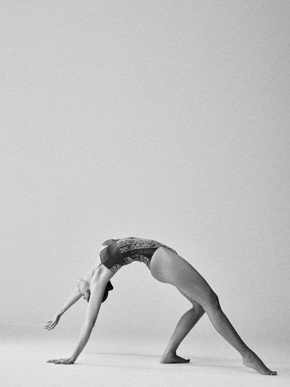 A graceful backbend. The high-contrast black and white photography emphasizes the musculature and lines of the yoga practitioner.