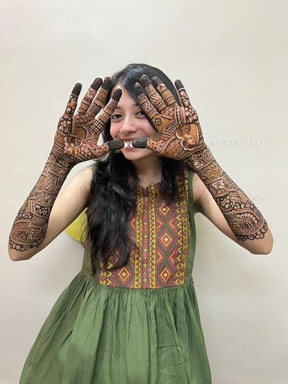 A fun and happy shot of the bride showcasing her full bridal mehendi.