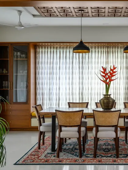 This grand dining room features two built-in crockery units flanking a large window, with glass doors for display and solid drawers for storage.