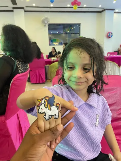 A happy guest showing off her brand new unicorn tattoo. My temporary tattoo artists are skilled at creating fun, colorful, and kid-safe designs that are a favorite at any party.