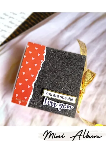 The cover of a mini album with a glittery black finish and a sweet 'Love you' message.