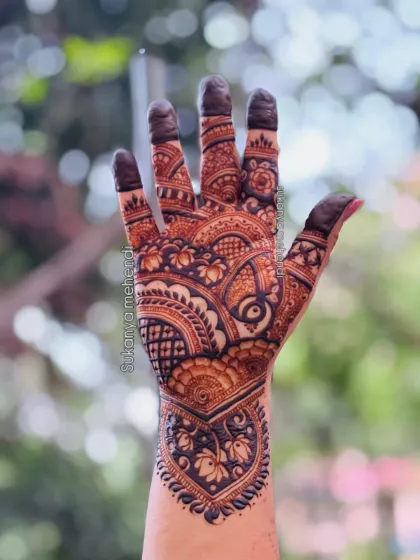 A full-hand design for a sider, featuring a mix of traditional Indian motifs like lotuses and paisleys, with filled-in fingertips for a classic look.