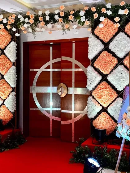 This entrance features pillars decorated with our signature floral cushion design in orange and white, creating a unique and textural welcome.
