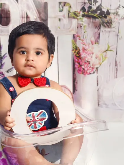 A pre-birthday photoshoot at my Ghaziabad studio. This setup uses a 'ONE' sign and a clean, bright background to create a classic first birthday portrait.