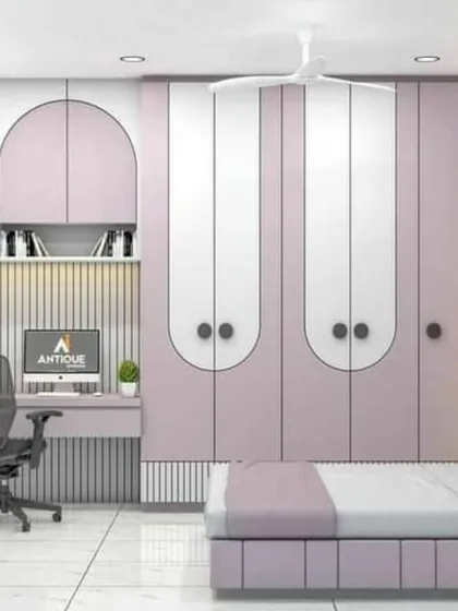 A beautiful kids' bedroom in a soft lilac and white palette. The wardrobe doors have a unique rounded design, and the study area is seamlessly integrated with open shelving.