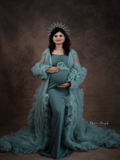 A portrait of pure elegance. The mom-to-be wears a crown and a beautiful sea-green gown from our studio collection, looking every bit the queen she is.