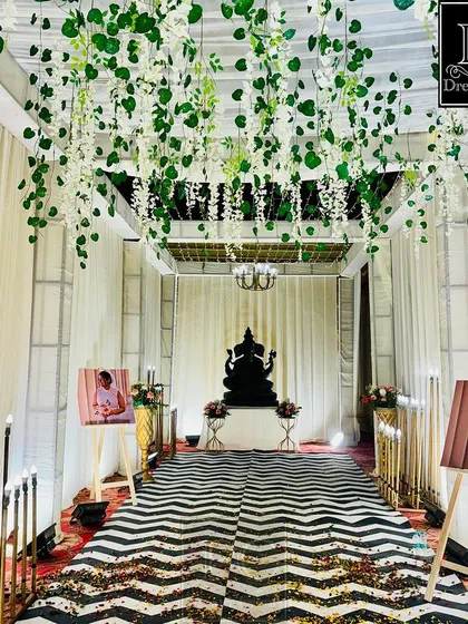 A modern and chic wedding walkway. I used a ceiling of hanging greenery, a bold black-and-white chevron runner, and personalized photo easels to create a stylish and personal entrance gallery.