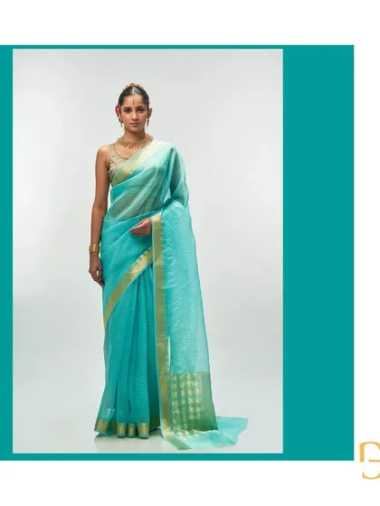 This aquamarine silk organza saree is fresh and vibrant. The delicate gold zari checks and floral pallu make it a light, festive option.