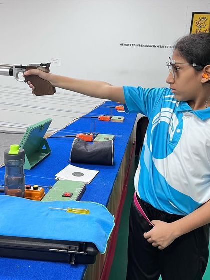 A young student demonstrates excellent form during an air pistol training session, highlighting the focus and discipline we teach.