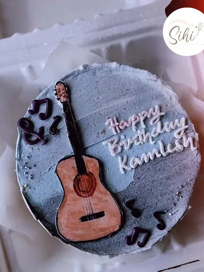 A musical-themed bento cake for a guitar player's birthday. The design includes a hand-drawn acoustic guitar surrounded by floating musical notes.