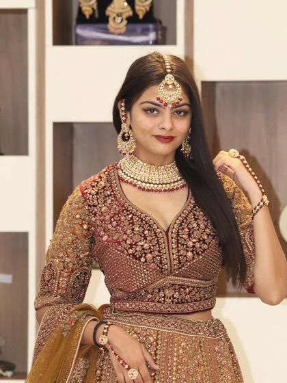 A close-up of the bride, highlighting the beautiful makeup, jewelry, and the detailed embroidery of the blouse.